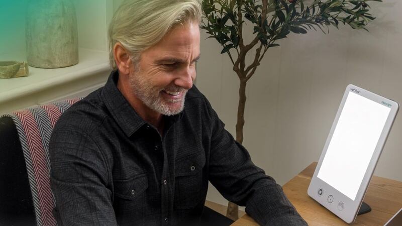A person using a light therapy lamp.