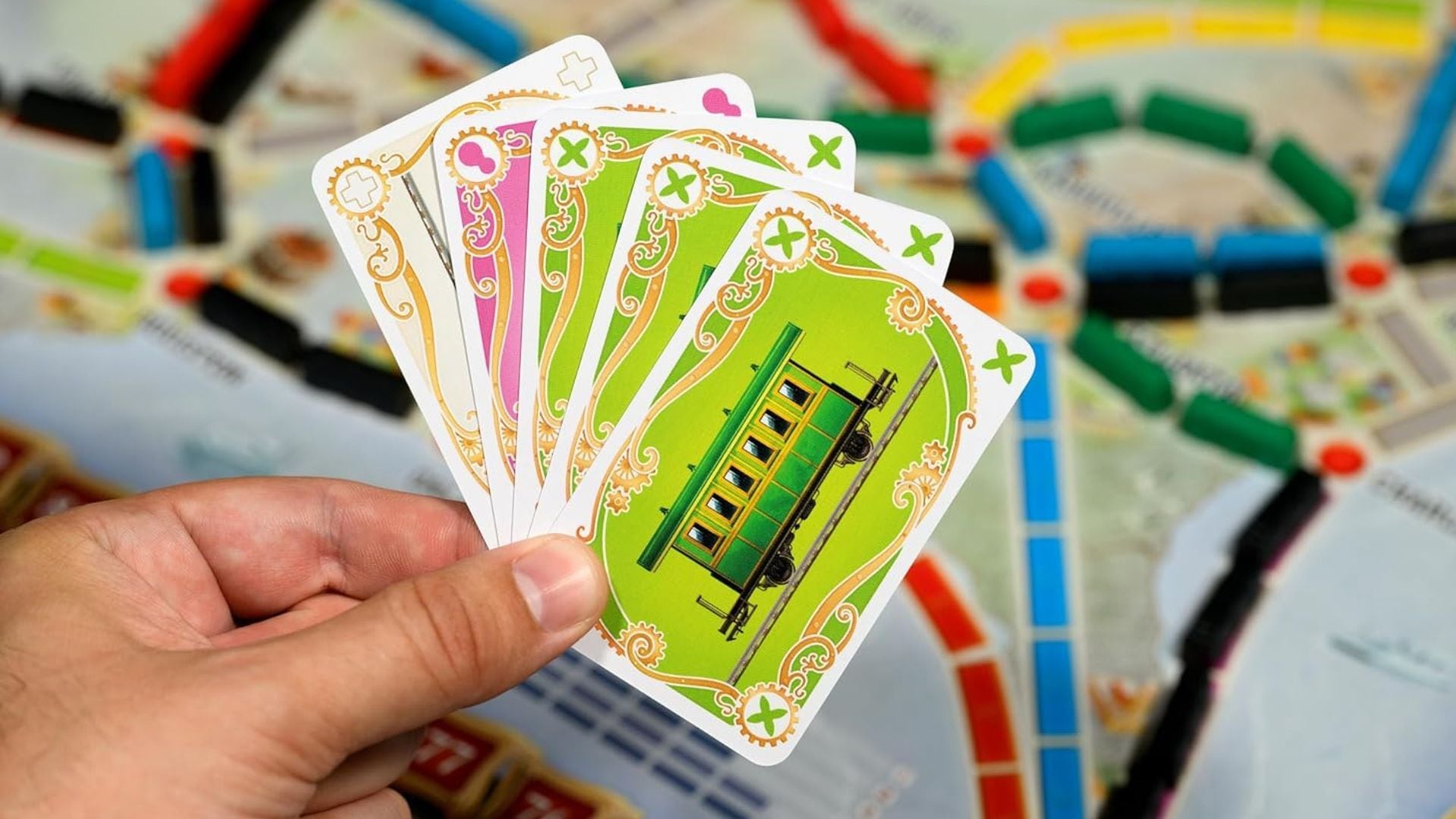 a person holding up themed cards over a board game.