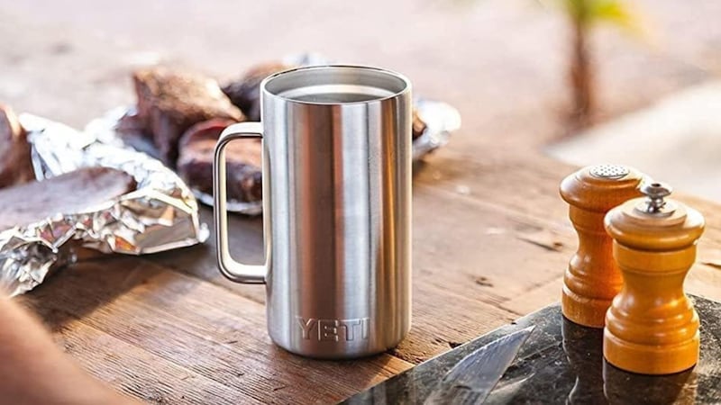A YETI Rambler 24 oz Mug on a picnic table.