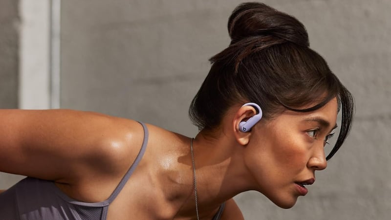 A person wearing blue Beats Powerbeats Pro 2 Wireless Bluetooth Earbuds.
