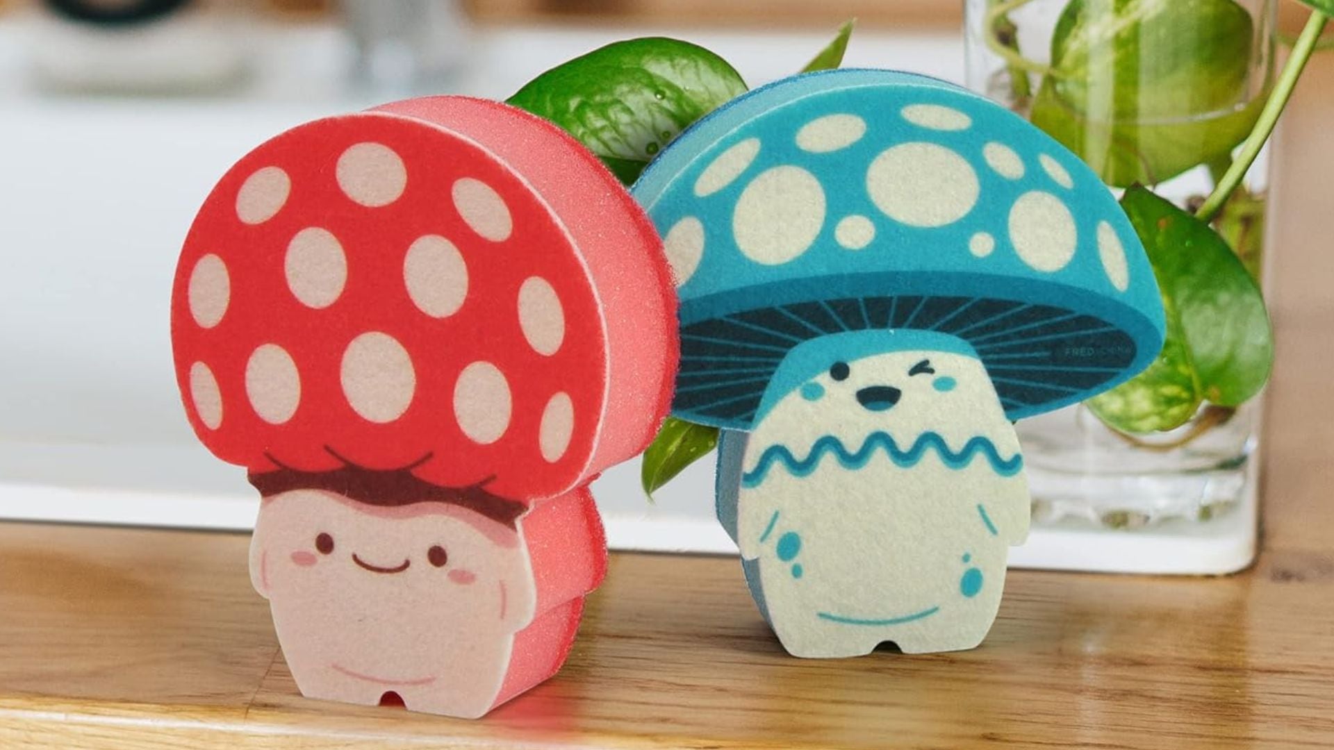 Two mushroom sponges on a wooden counter