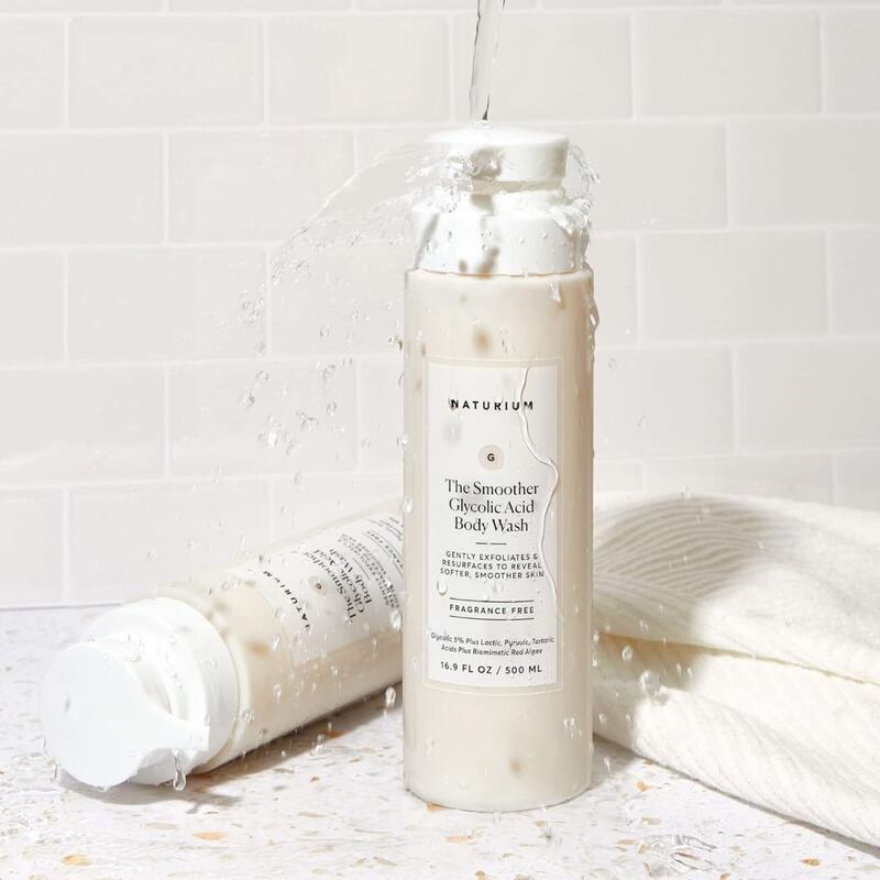 Two bottles of Naturium body wash next to a towel.