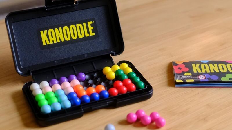 The Educational Insights Kanoodle 3D Brain Teaser Puzzle Game on a wooden table.